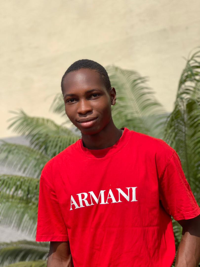 Samuel Success Sunday wearing a red Armani shirt in Anyigba